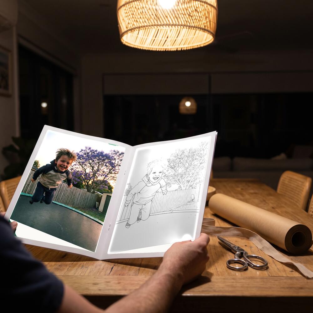 A photo on the left page and the same moment as a colouring page on the right.